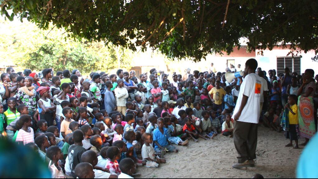 Volunteer educating Malawian village on HIV